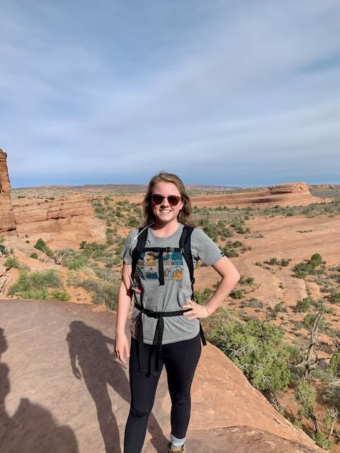 Haleigh on the third section of the Delicate arch hike which winds around on a you hike a ledge