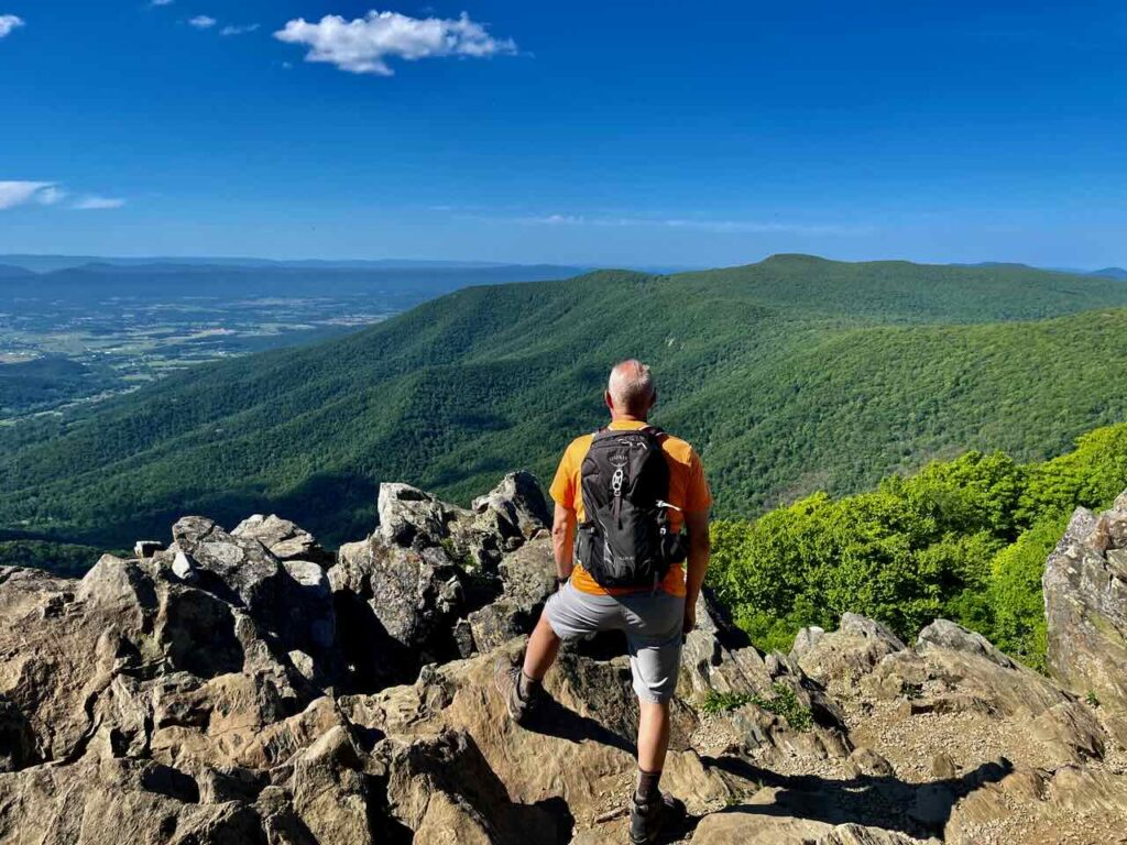 Steve is standing at the overlook at Hawksbill Summit. 