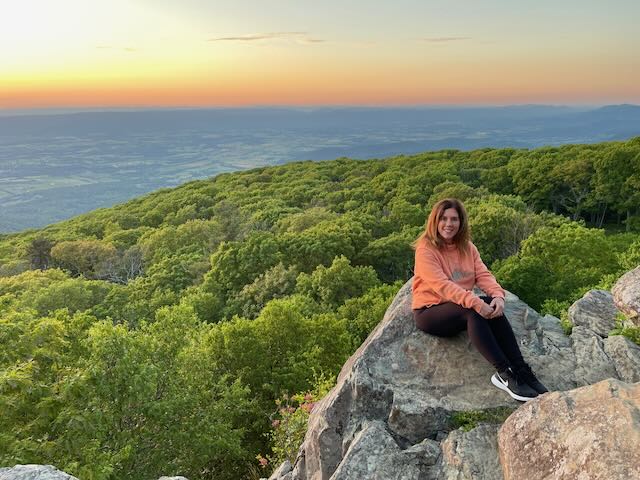 Lori is posing for a picture with the valley behind her at Black Rock Trail. 