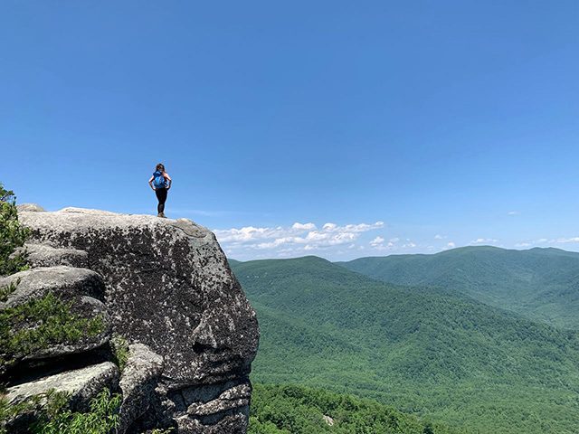 Lori standing at the peak of Old Rag Trail and looking down at the valley in Shenandoah National Park