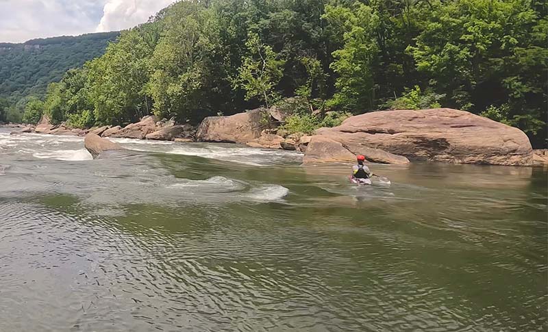 A kayaker paddling down the new river.  