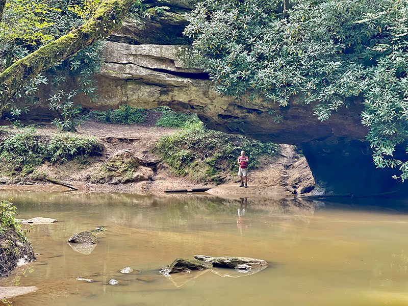 View of Rock Bridge Arch with Steve looking into the river.  